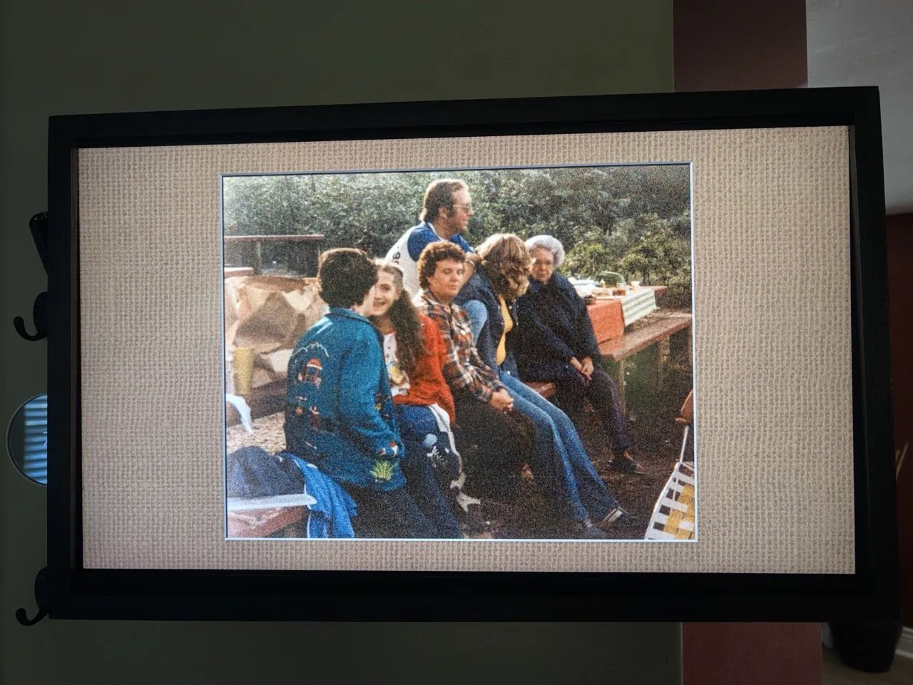 The finished frame, built from an old TV, showing a vintage family photo in a textured linen mat