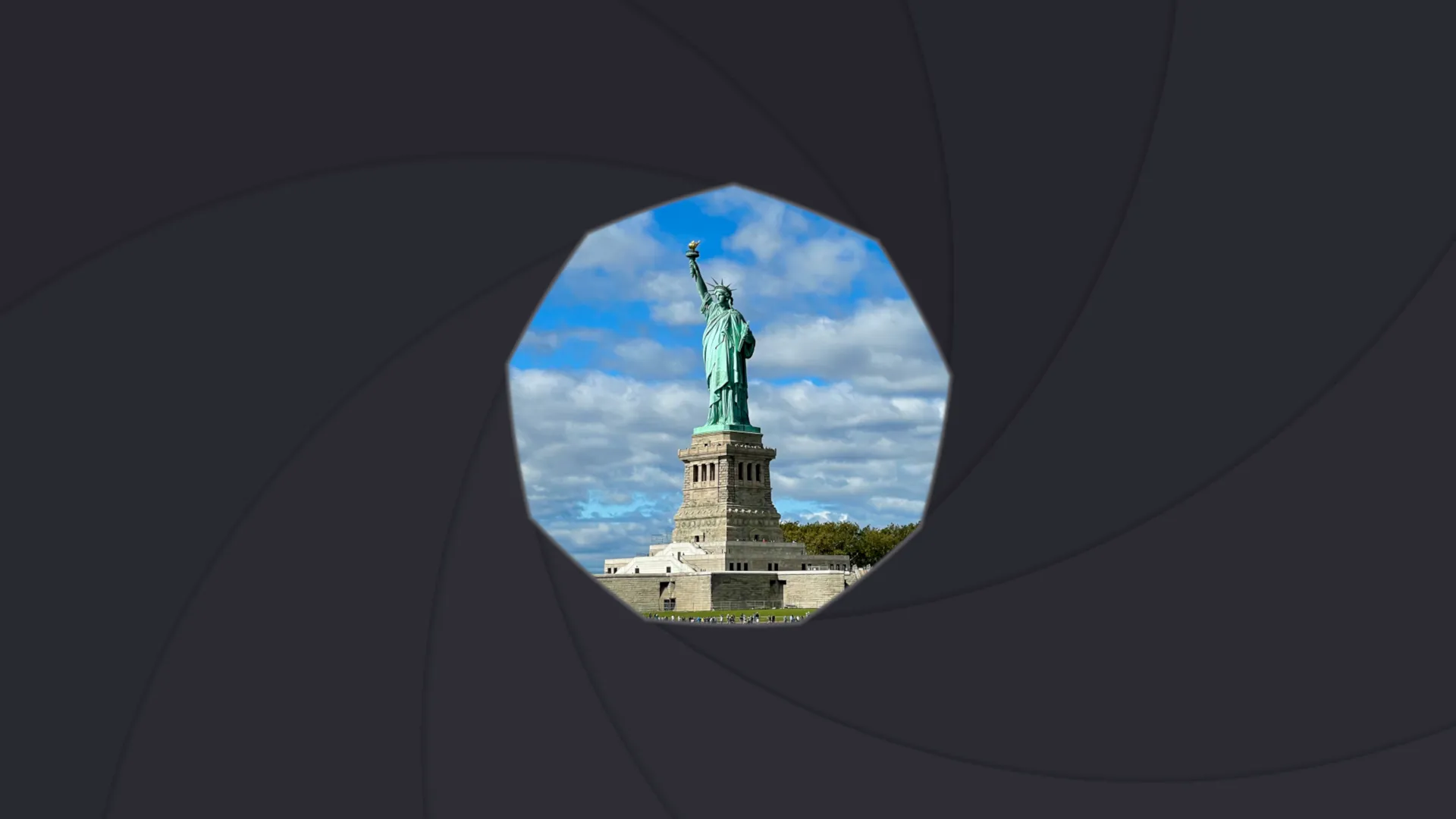 Nine dark camera-iris blades closed into a polygonal aperture around the Statue of Liberty, the blades curving in a slight spiral